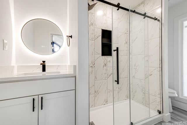 full bath with toilet, a marble finish shower, and vanity