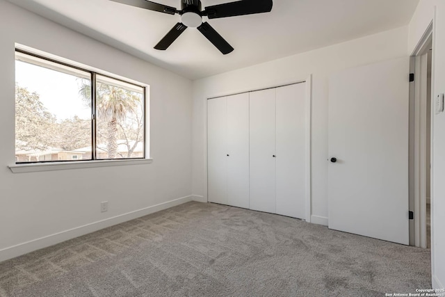 unfurnished bedroom with a closet, carpet flooring, ceiling fan, and baseboards