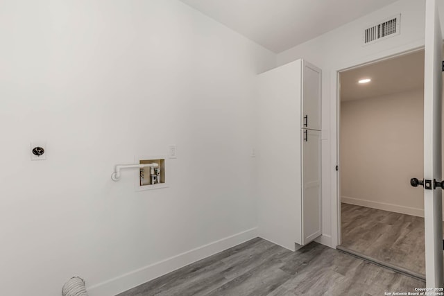 washroom with hookup for a washing machine, baseboards, visible vents, and wood finished floors