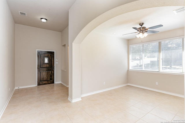 entryway featuring arched walkways, visible vents, ceiling fan, and baseboards