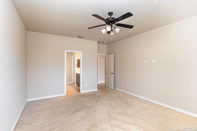 unfurnished bedroom with baseboards, visible vents, ceiling fan, and light colored carpet