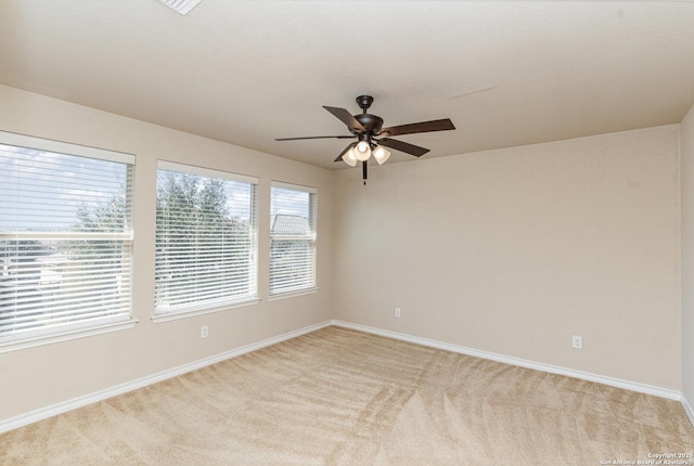 unfurnished room with light carpet, ceiling fan, and baseboards