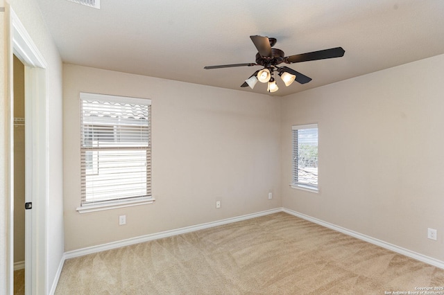 empty room featuring carpet floors, ceiling fan, and baseboards