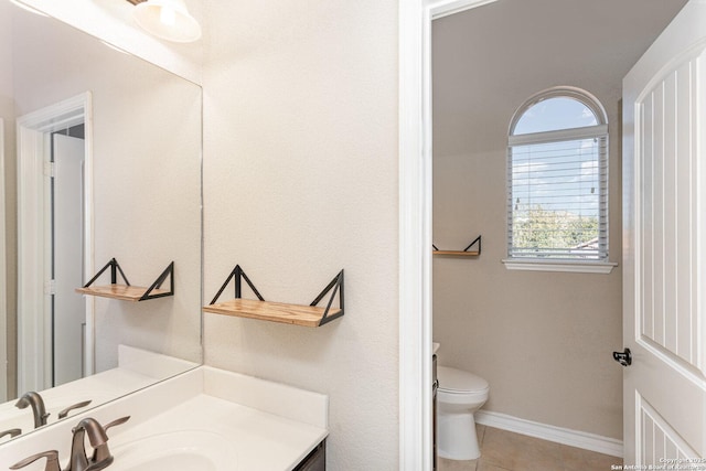 bathroom featuring toilet, tile patterned flooring, baseboards, and vanity