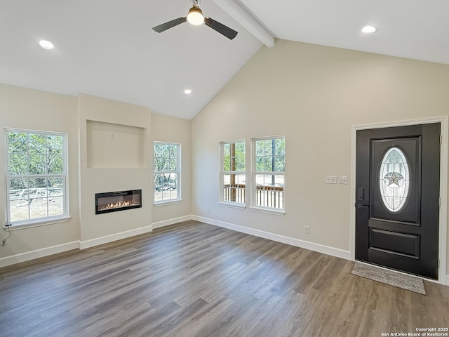660 Skyline Dr, Bandera, TX 78003 - entryway featuring wood finished floors, beam ceiling, a glass covered fireplace, and a wealth of natural light
