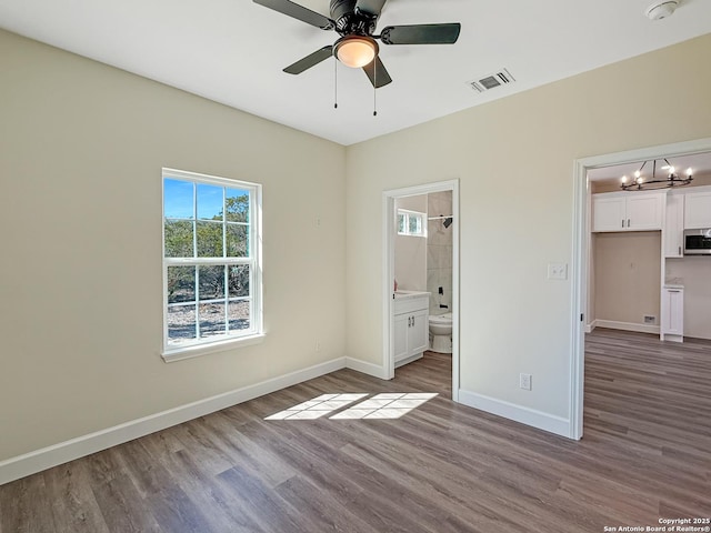 660 Skyline Dr, Bandera, TX 78003 - unfurnished bedroom with connected bathroom, wood finished floors, visible vents, and baseboards