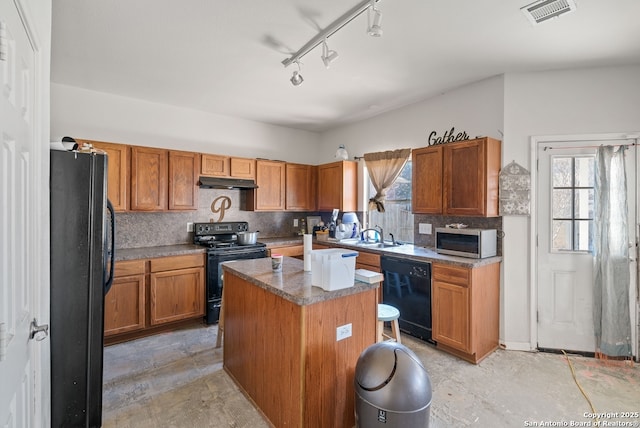 kitchen with tasteful backsplash, visible vents, under cabinet range hood, and black appliances