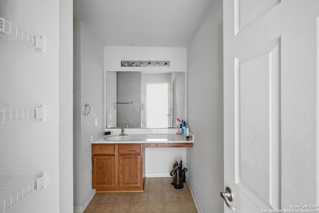 bathroom featuring vanity, baseboards, and tile patterned floors