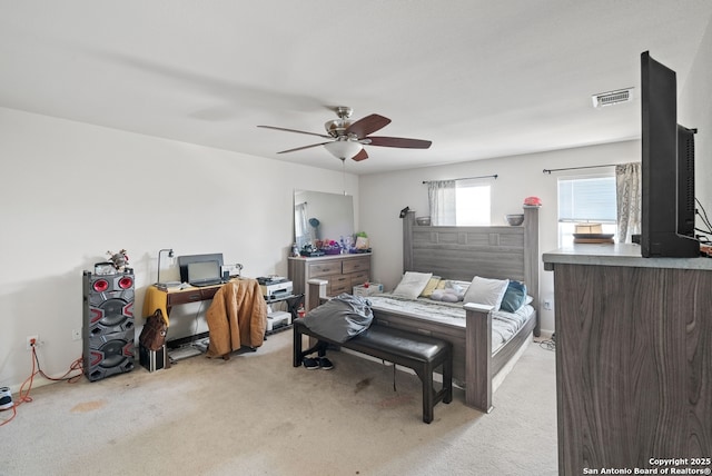 bedroom featuring light carpet, visible vents, and a ceiling fan