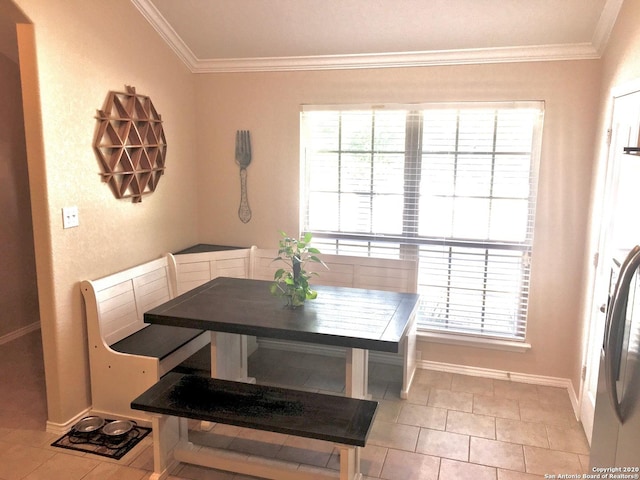 dining space featuring crown molding, baseboards, and light tile patterned floors