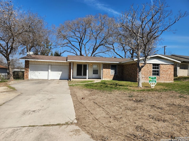 ranch-style house with an attached garage, concrete driveway, and brick siding