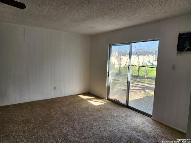 carpeted empty room featuring a textured ceiling