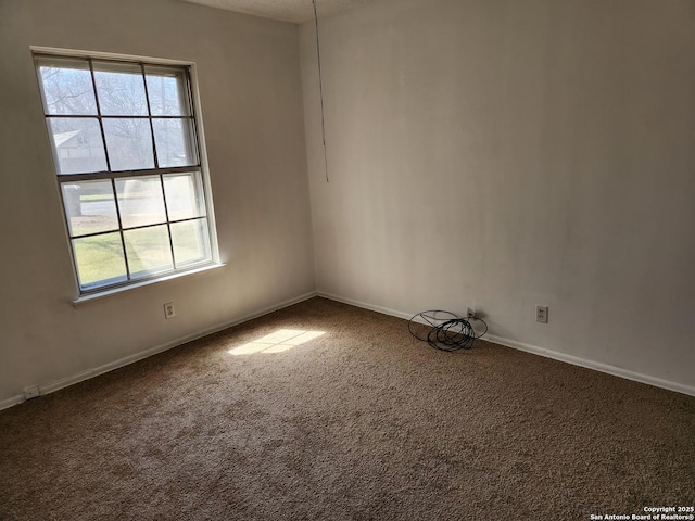 spare room featuring carpet floors and baseboards