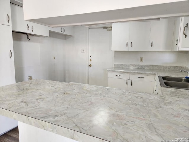 kitchen featuring white cabinetry and a sink