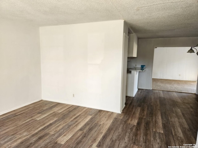 spare room with dark wood-style floors and a textured ceiling