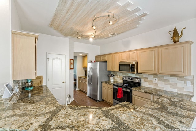 kitchen with stone countertops, stainless steel appliances, backsplash, and light brown cabinetry