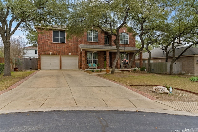 traditional-style house featuring brick siding, an attached garage, a front yard, fence, and driveway