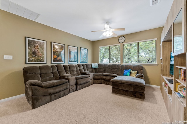 living area with baseboards, visible vents, a ceiling fan, and light colored carpet