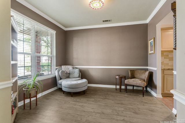 sitting room with visible vents, crown molding, light wood-style flooring, and baseboards