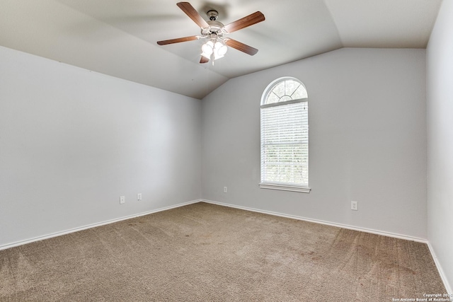 carpeted spare room featuring vaulted ceiling, ceiling fan, and baseboards