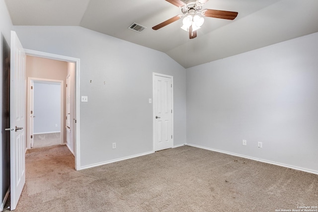 unfurnished bedroom with carpet flooring, a ceiling fan, visible vents, vaulted ceiling, and baseboards