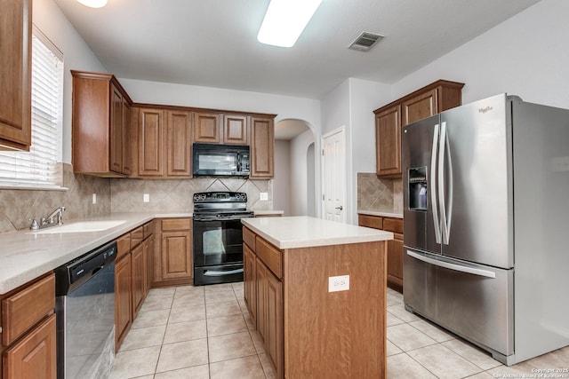 kitchen featuring visible vents, a kitchen island, black appliances, and light tile patterned flooring