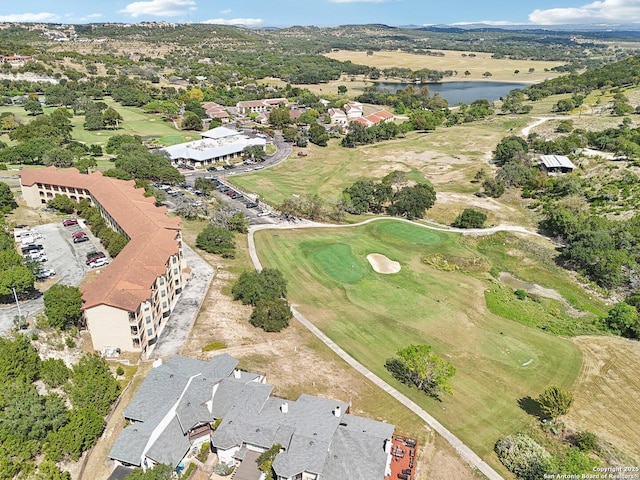 drone / aerial view featuring golf course view and a water view