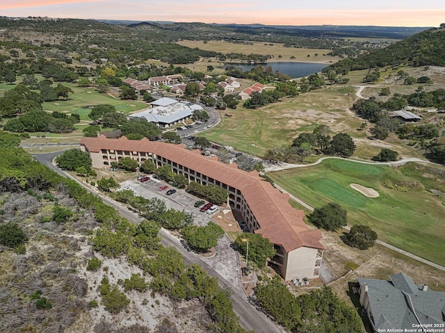 drone / aerial view featuring view of golf course and a water view