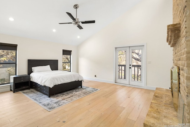 bedroom featuring access to exterior, french doors, wood finished floors, high vaulted ceiling, and baseboards