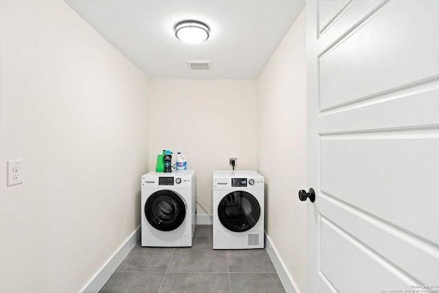 clothes washing area with laundry area, baseboards, visible vents, and washer and dryer