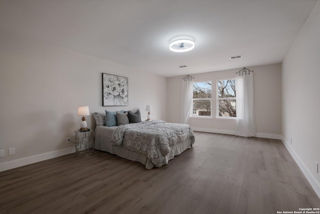 bedroom featuring wood finished floors, visible vents, and baseboards