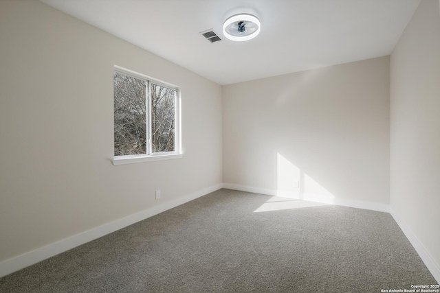 unfurnished room featuring baseboards, visible vents, and carpet flooring