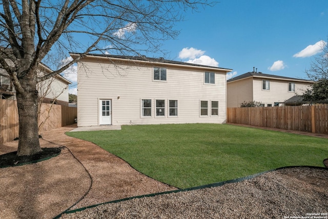 rear view of property with a patio area, a fenced backyard, and a yard