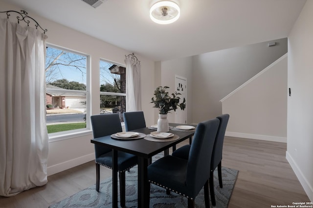 dining area with baseboards and wood finished floors