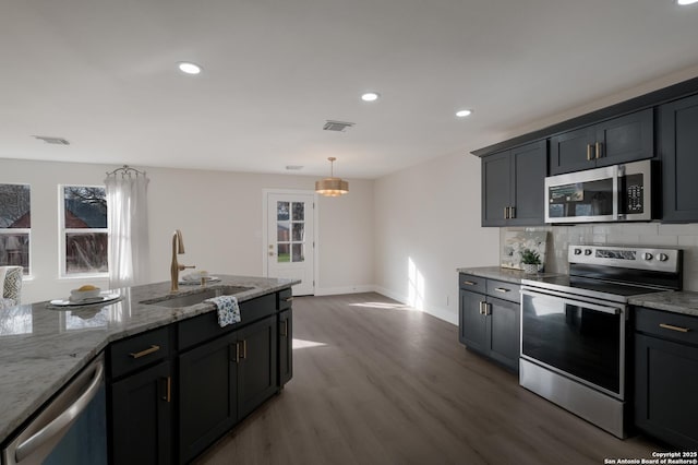 kitchen featuring visible vents, stainless steel appliances, a sink, and wood finished floors