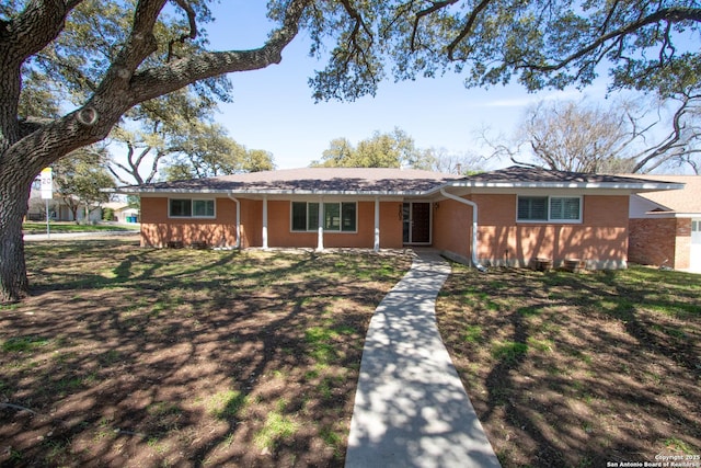 ranch-style home with a front yard and brick siding