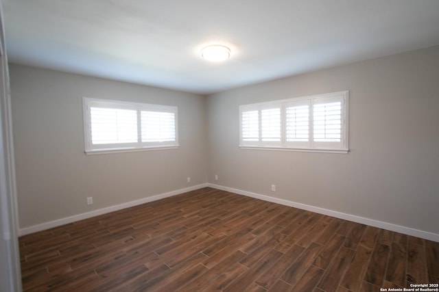 empty room with dark wood-style floors and baseboards