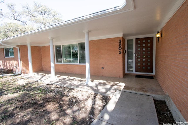 entrance to property featuring brick siding