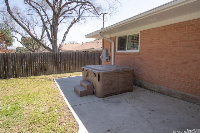 view of patio / terrace featuring fence and a hot tub