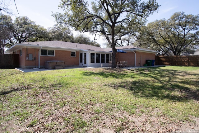 rear view of property featuring a patio area, fence, a lawn, and brick siding