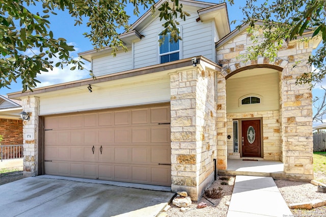 traditional home with a garage, stone siding, and concrete driveway