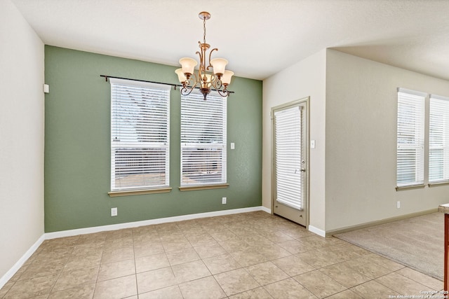 interior space featuring light tile patterned flooring, baseboards, and an inviting chandelier