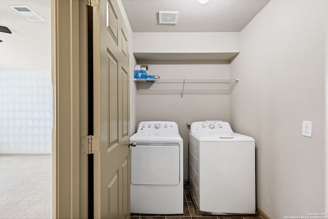 laundry area featuring laundry area, visible vents, washer and clothes dryer, and a textured ceiling