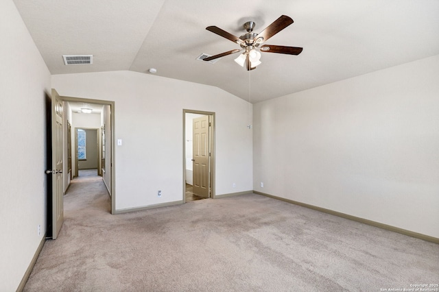 unfurnished bedroom featuring light colored carpet, visible vents, a ceiling fan, vaulted ceiling, and baseboards