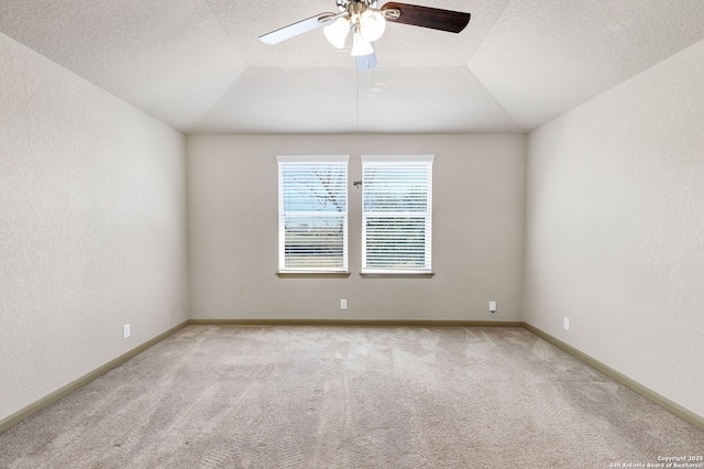 empty room featuring a textured ceiling, carpet floors, and lofted ceiling