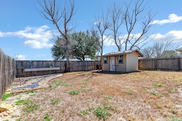 view of yard with a fenced backyard and an outbuilding