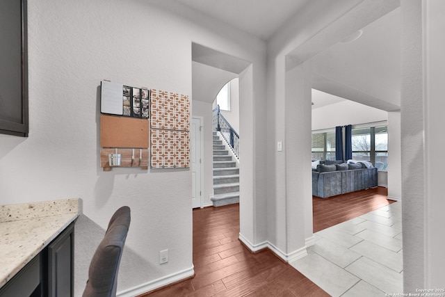 interior space with stairway, baseboards, and wood finished floors