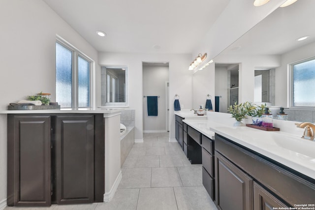 full bathroom featuring double vanity, a bath, tile patterned flooring, an enclosed shower, and a sink