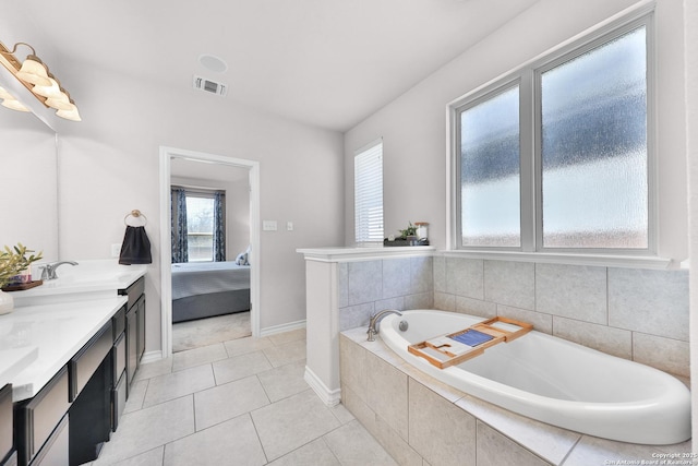 ensuite bathroom with tile patterned flooring, connected bathroom, a sink, visible vents, and a bath