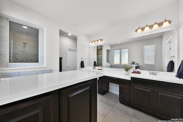 full bath featuring tile patterned flooring, tiled shower, and vanity